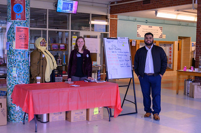 volunteers standing behind table and posing for camera