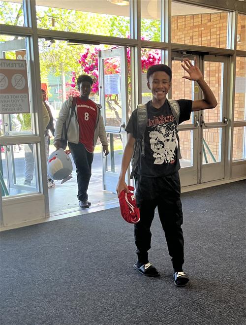 student walking in the front doors of the school
