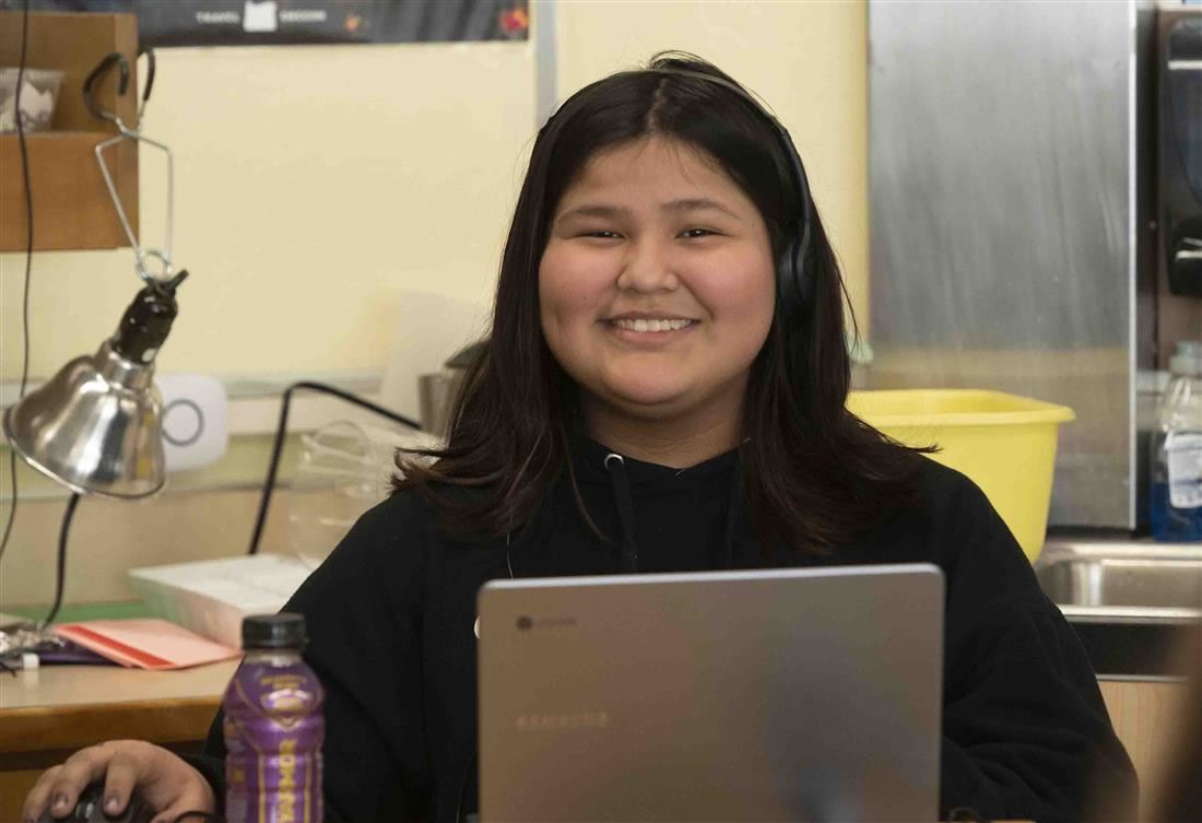 Student posing in front of laptop