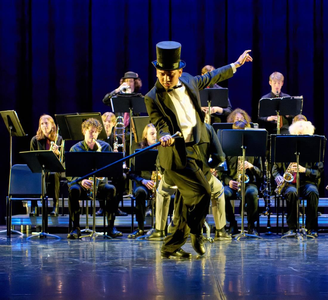 Student in top hat and tuxedo dancing