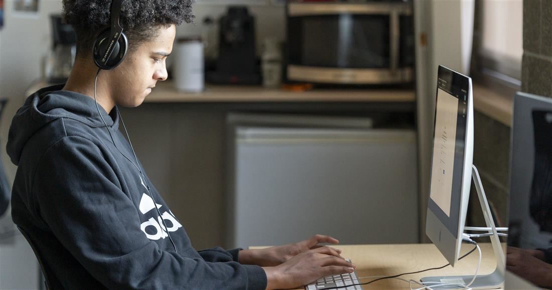 Student wearing headphones working on computer