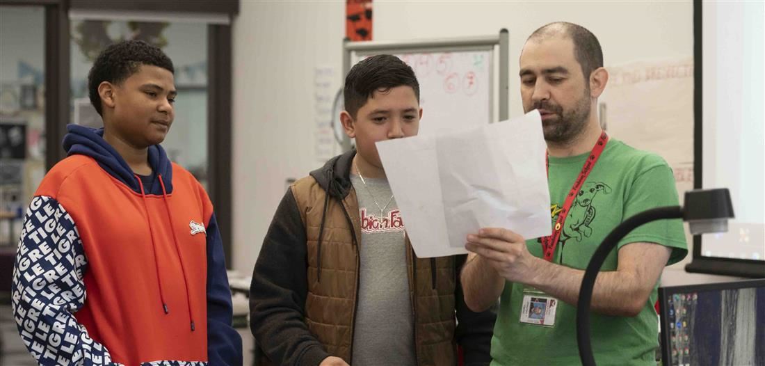 Two students reviewing document with instructor
